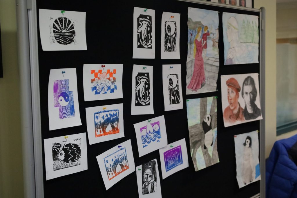 Vibrant art collection on black board showcasing diverse styles and colorful designs.