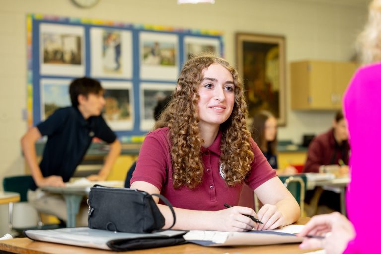 Engaged student in a lively classroom setting, focused on learning and collaboration.