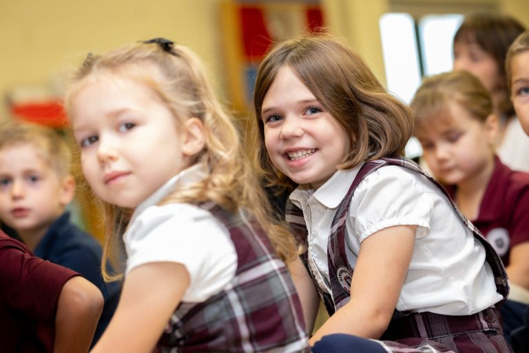 Children in a colorful classroom engage joyfully, showcasing camaraderie and early learning.