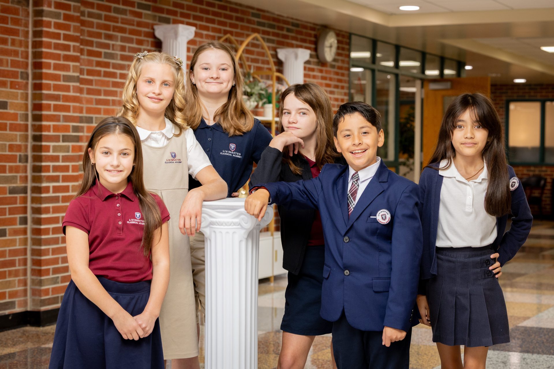 Cheerful school children in uniforms pose together, showcasing friendship and unity in education.